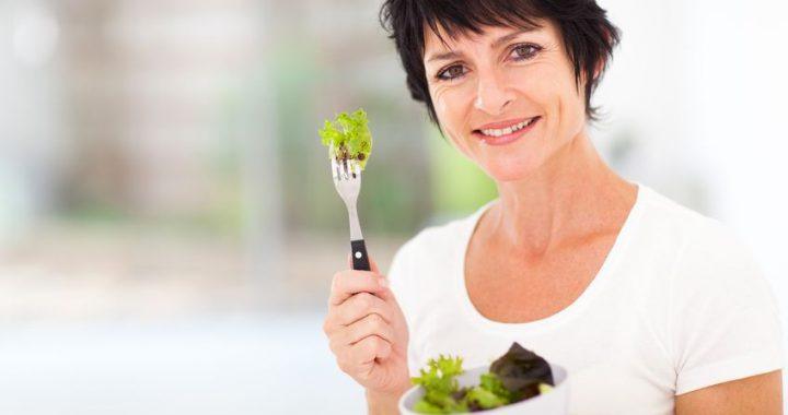attractive mature woman with fresh green salad at home