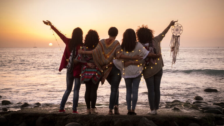 Group of women enjoying life, on beach at sunset